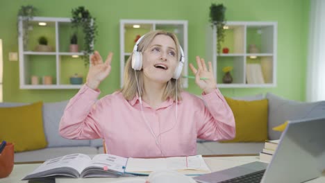 estudiante universitaria bailando mientras estudia.