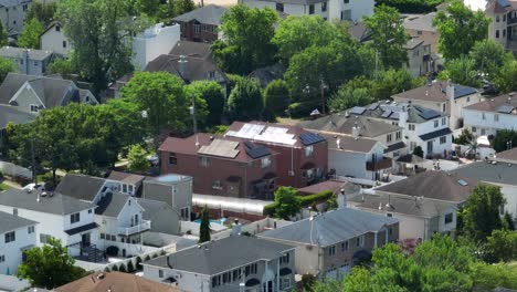 aerial wide shot of american luxury villas with solar panels on rooftop in tottenville, staten island with bay water in background - new york city,usa