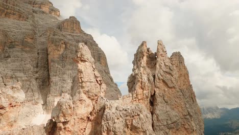 FPV-drone-gracefully-maneuvers-around-Col-De-Bos-mountain's-stunning-rock-formations,-capturing-their-rugged-beauty-from-unique-angles