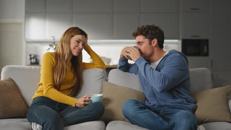 chatting duet drinking tea at sofa interior closeup. woman listening husband