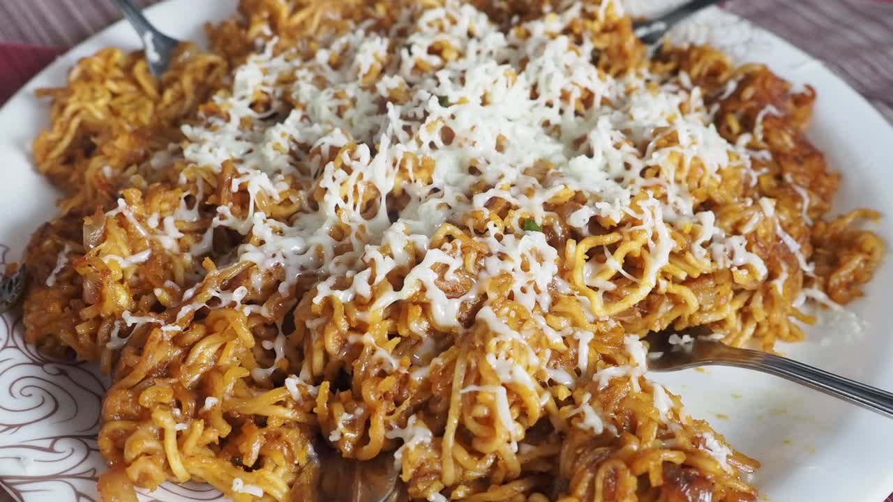 fideos maggie de queso, fideos instantáneos servidos en un plato cubierto con queso y luego colocados sobre un fondo de color, enfoque selectivo