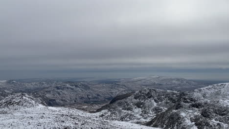 una vista panorámica de las montañas cubiertas de nieve y una vista impresionante en la cima de scafell pike, en el distrito de los lagos, inglaterra