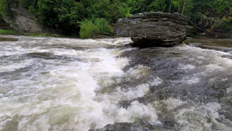 water flows down linville river below linville falls waterfall