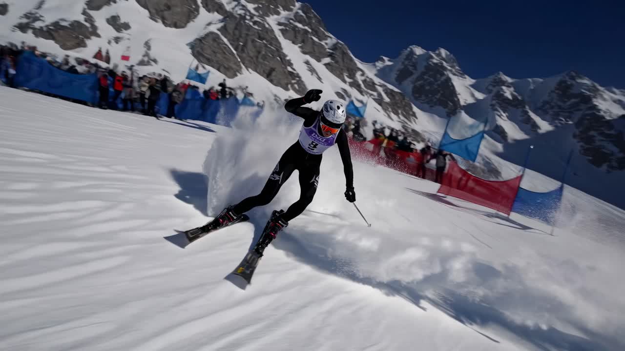 Dynamic video still of a skier racing downhill, captured from a low angle, showcasing speed
