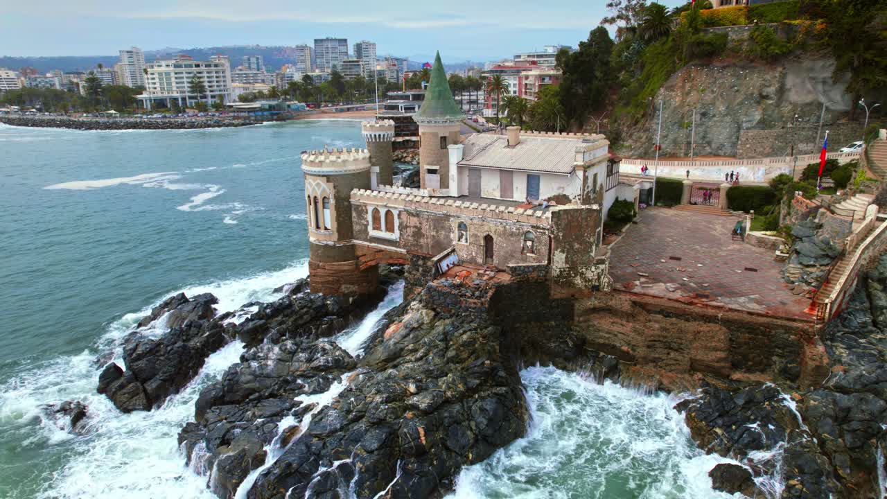 Aerial orbit establishing in the destroyed Wulff Castle, heritage of the city of Viña del Mar, castle on the rocks on the coast of the beach.
