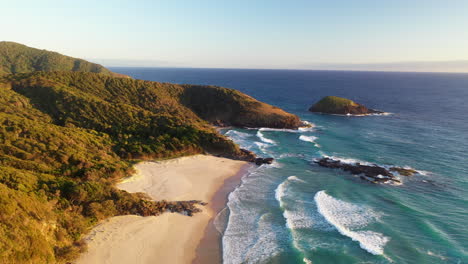 cinematic drone shot of north smoky beach, the ledge and green island near smoky cape lighthouse, australia