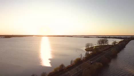 puesta de sol sobre un lago sereno con un camino