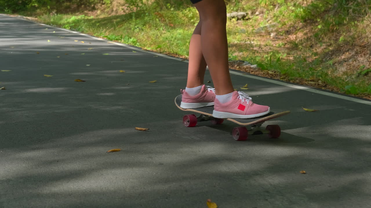 Woman Skateboarding on a Road