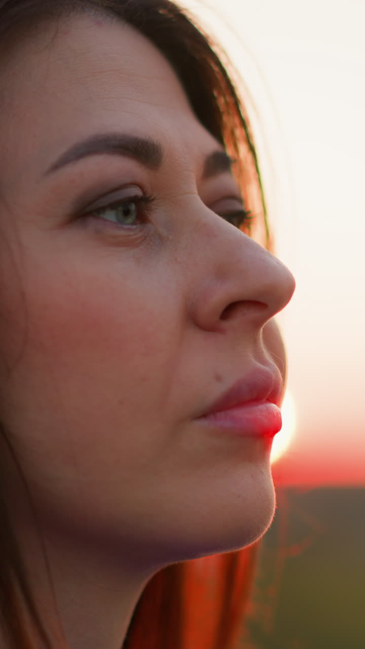 mujer con pensamientos negativos contra el sol del anochecer de cerca. hermosa dama se ocupa de sentimientos duros caminando por el campo de la noche. estado de ánimo melancólico