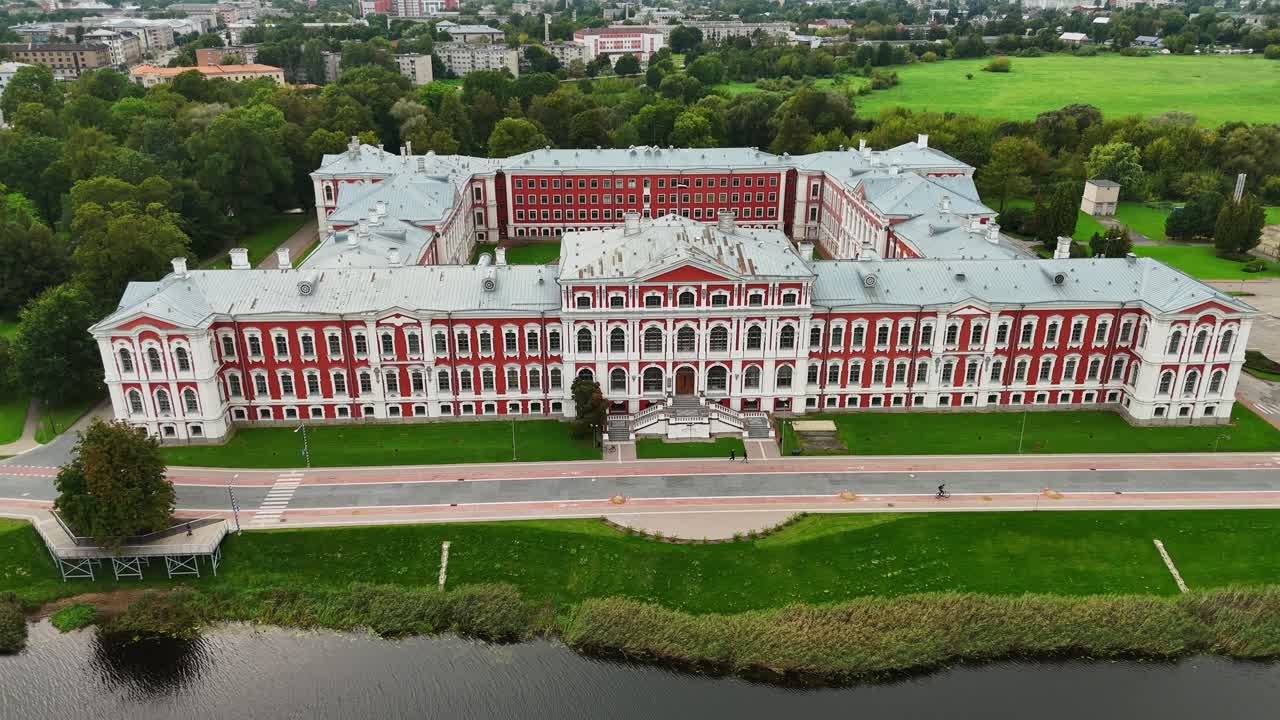 Drone shot of cyclist riding past Jelgava Palace in Latvia