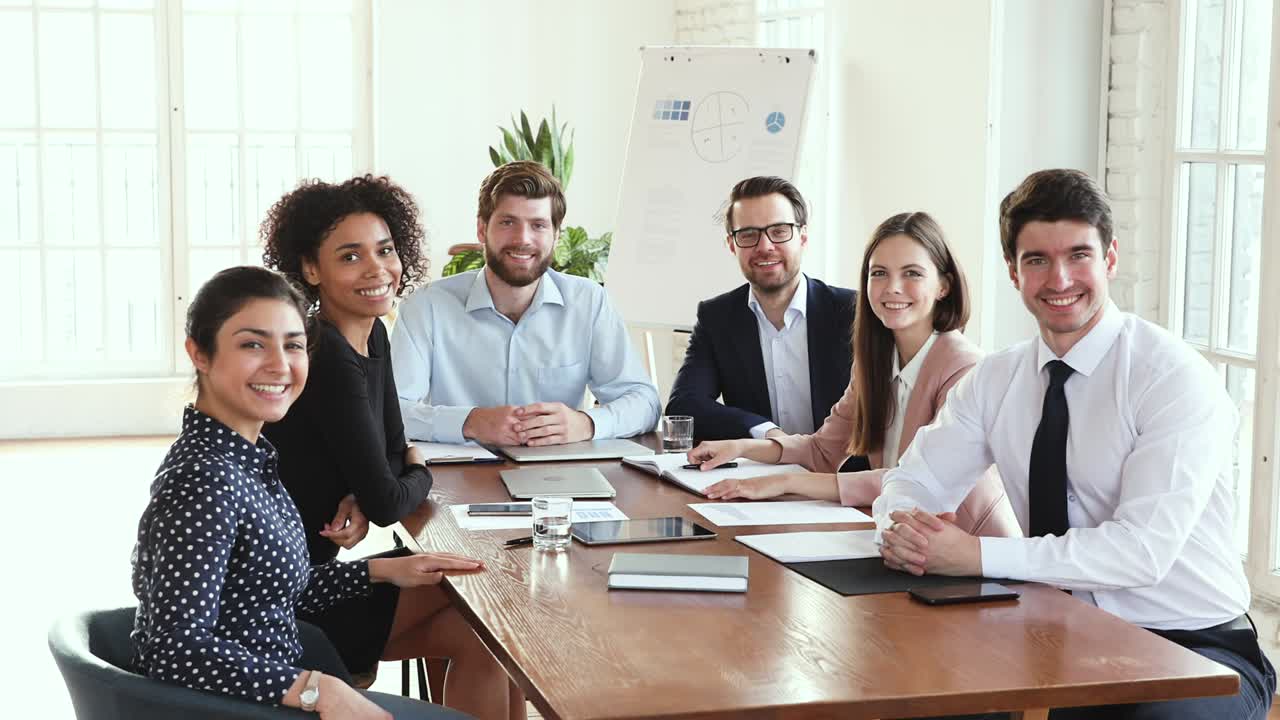 grupo de la junta de una empresa multicultural feliz posando en la mesa de reuniones de la oficina
