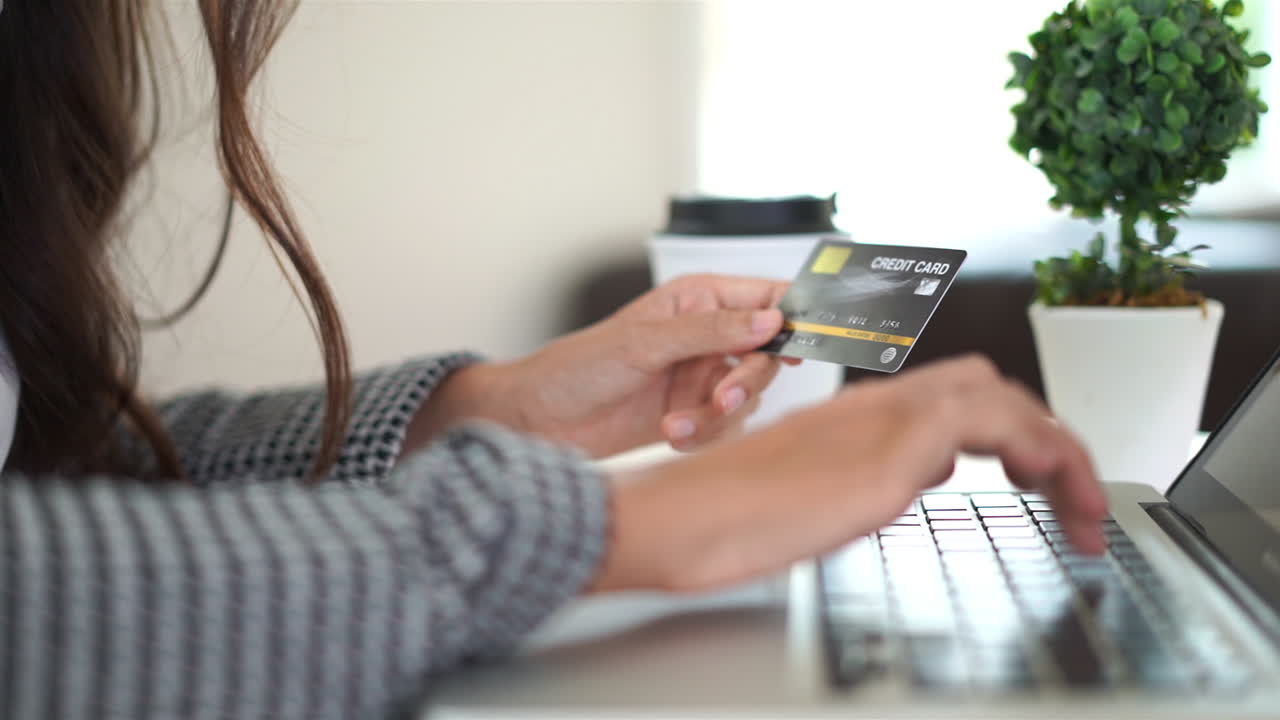 Close up of a woman carefully inputting her credit card number into a website