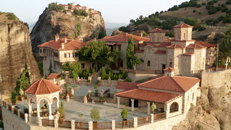 monastery of varlaam on clifftop in meteora during sunrise in greece