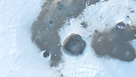 above mud pools covered in winter white snow at gunnuhver geothermal field