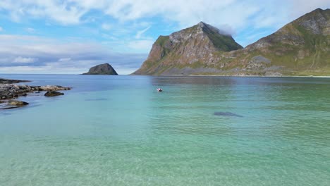 playa de haukland y barco en el mar ártico en verano en la isla de lofoten, noruega - 4k aéreo