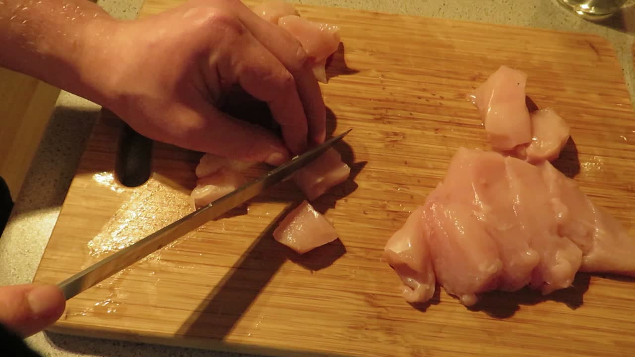Timelapse del taglio di pollo a bocconcini in preparazione di una ricetta con pollo, salsa rossa e pasta