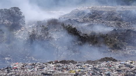 smoke fills air above burning landfill garbage dump site in guatemala