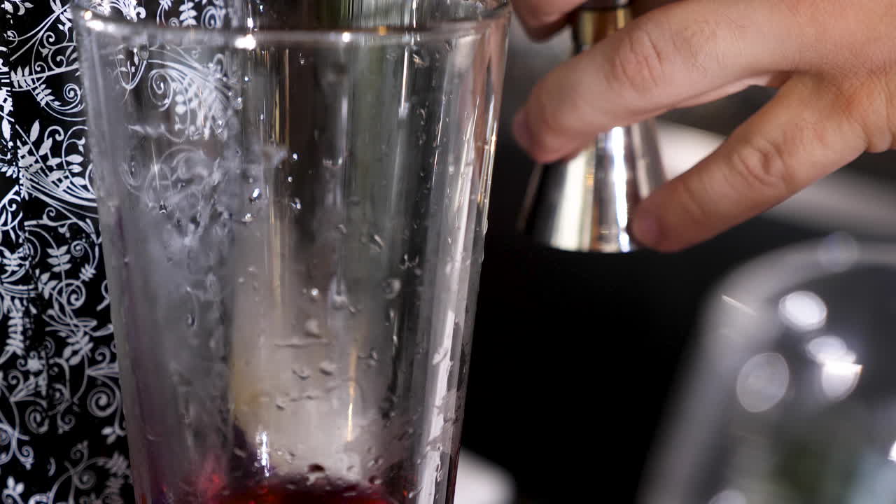 Close-up of a person pouring liquid into a glass
