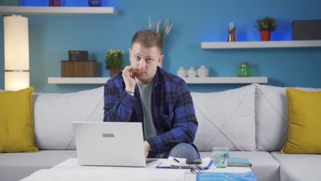 Hombre-Trabajador-De-Oficina-En-Casa-Mordiéndose-Las-Uñas-Mirando-A-La-Cámara.