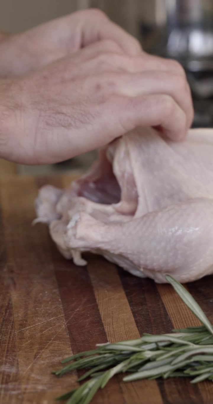 Chef che prepara un pollo intero crudo per la cottura al forno