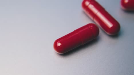 red medical capsules lie on clean white background