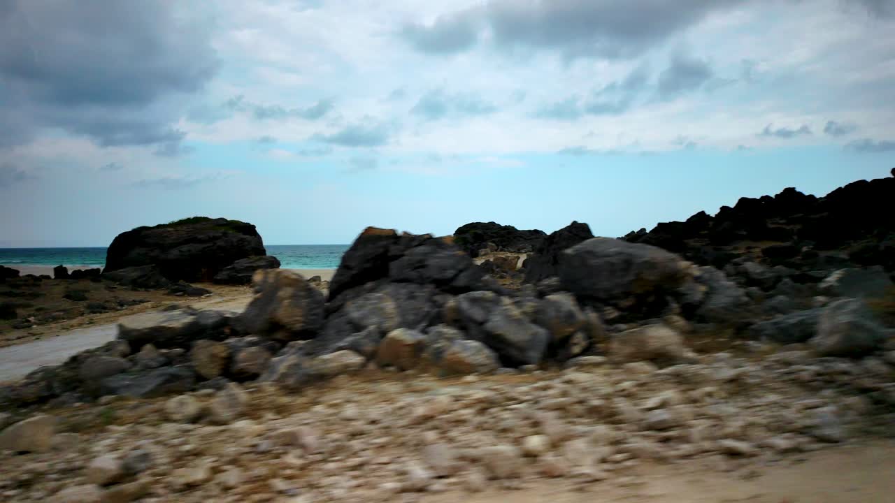 Driving along a dirt road to reveal a picturesque beach along the Omani coast near Salalah