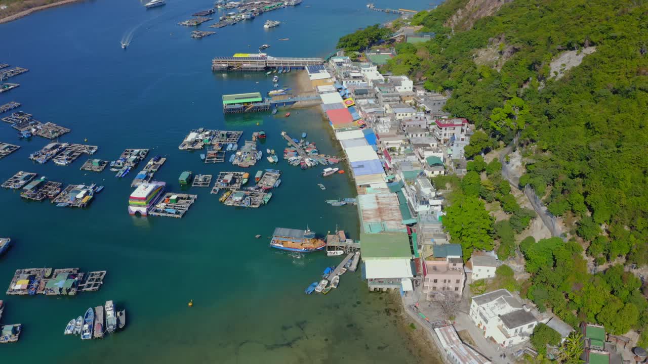 낮에는 부두와 굴 양식장이 있는 작은 어촌 위로 왼쪽으로 이동하는 드론 샷