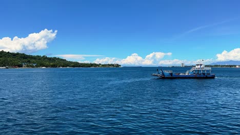 ferry boat sails across deep blue tropical waters with lush shoreline and vivid sky—ideal for travel or maritime content