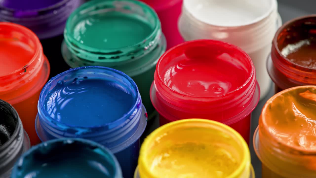 fondo de primer plano giratorio en bucle de pequeños frascos de pintura de gouache abiertos