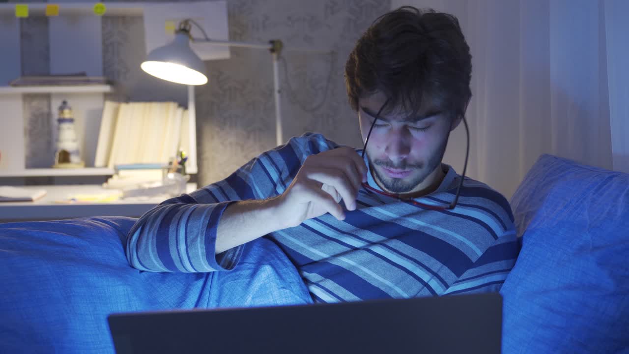 Person falling asleep while looking at laptop in bed.