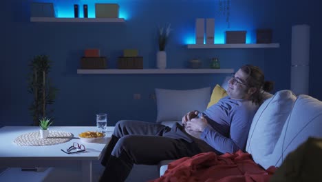 hombre gracioso rascándose la barriga mientras ve la televisión.