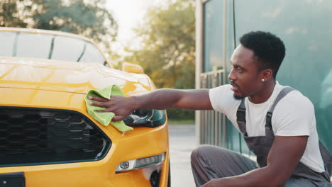 man washing a yellow car