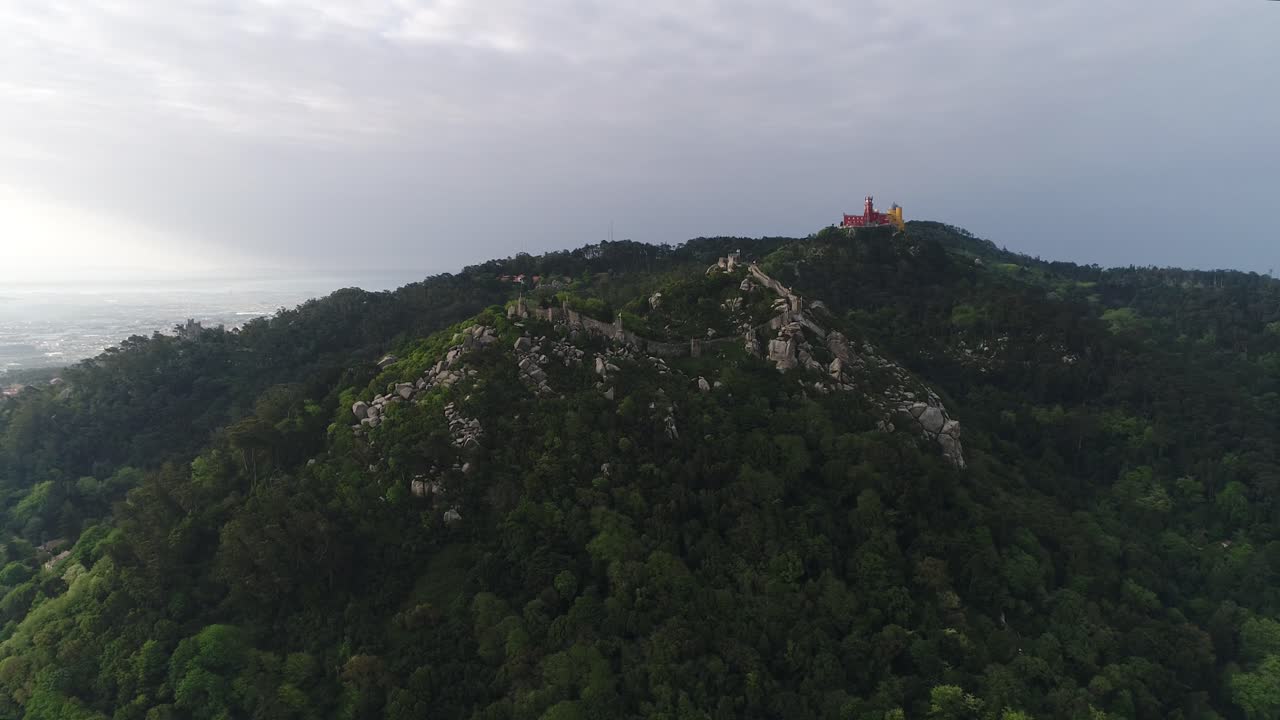 vista aérea de la ciudad de sintra en portugal, la histórica fortaleza de castelo dos mouros, las murallas y el palacio de pena en el verano, tomada con un dron, en una hermosa cumbre verde en la cima de una colina rocosa