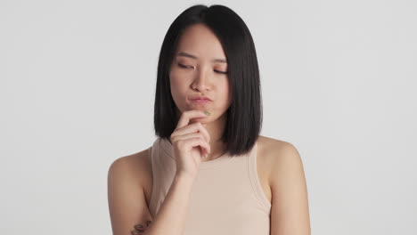 Asian-woman-thinking-and-having-and-idea-on-camera.