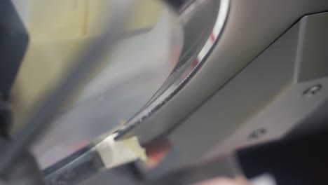 primer plano de lonchas de queso saliendo de una máquina rebanadora