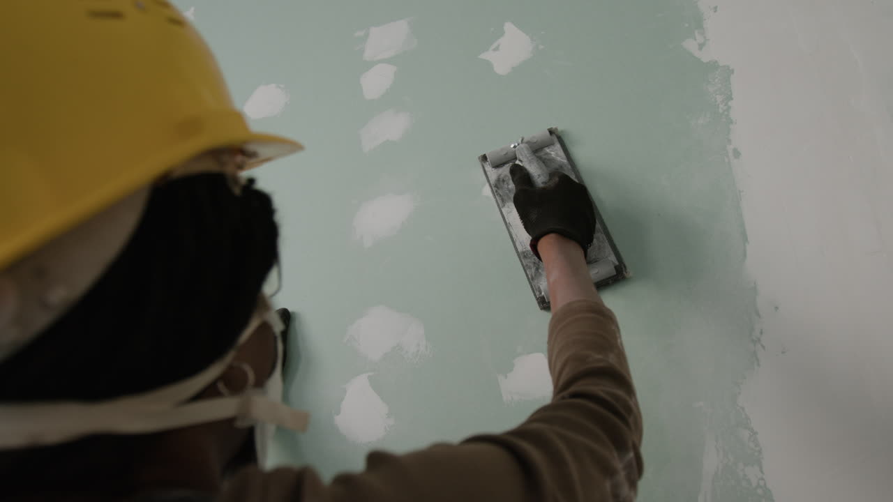 Construction worker repairing drywall