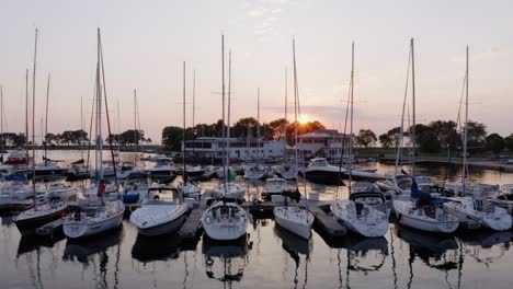 Drones-Volando-Lejos-De-Los-Barcos-Atracados-En-El-Puerto-Deportivo-Durante-La-Hermosa-Puesta-De-Sol-De-Verano