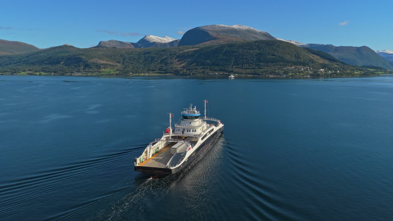 Grøn energifærge glider over rolig fjord i Norge, droneudsigt