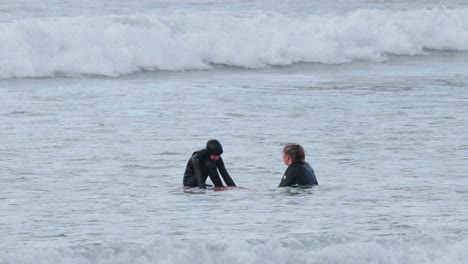 two surfers interacting in ocean waves