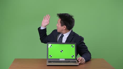 녹색 배경에 성숙한 일본 사업가