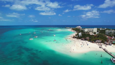 Vuelo-Panorámico-De-Drones-Sobre-El-Océano-Azul-Brillante-Con-Arena-Blanca-Y-Balnearios-De-Playa-Norte,-Isla-Mujeres-México,-4k