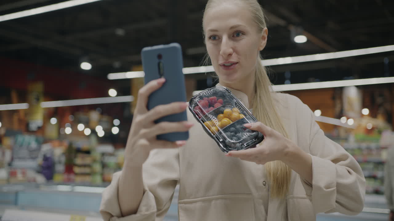 Woman using phone in a supermarket