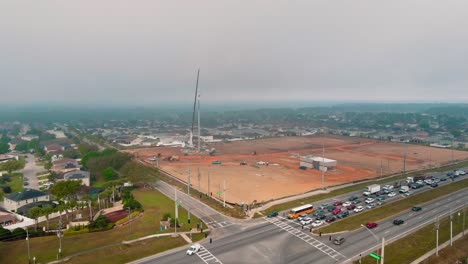 A-4k-Drone-shot-flying-towards-a-construction-site-were-2-workers-a-being-lowered-by-a-construction-crane-who-were-working-on-fixing-a-cellphone-tower