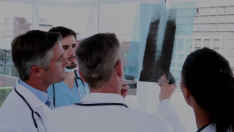 animación del procesamiento de datos financieros sobre un equipo de diversos médicos que examinan radiografías en el hospital