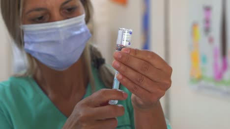 a nurse prepares a shot of sputnik v vaccine. handheld.