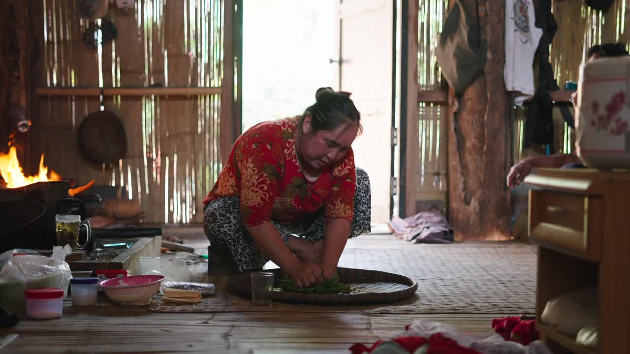 Wanita Menyiapkan Makanan di Rumah Tradisional