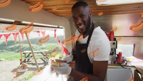 animation of hot dog icons over happy african american man preparing hot dog