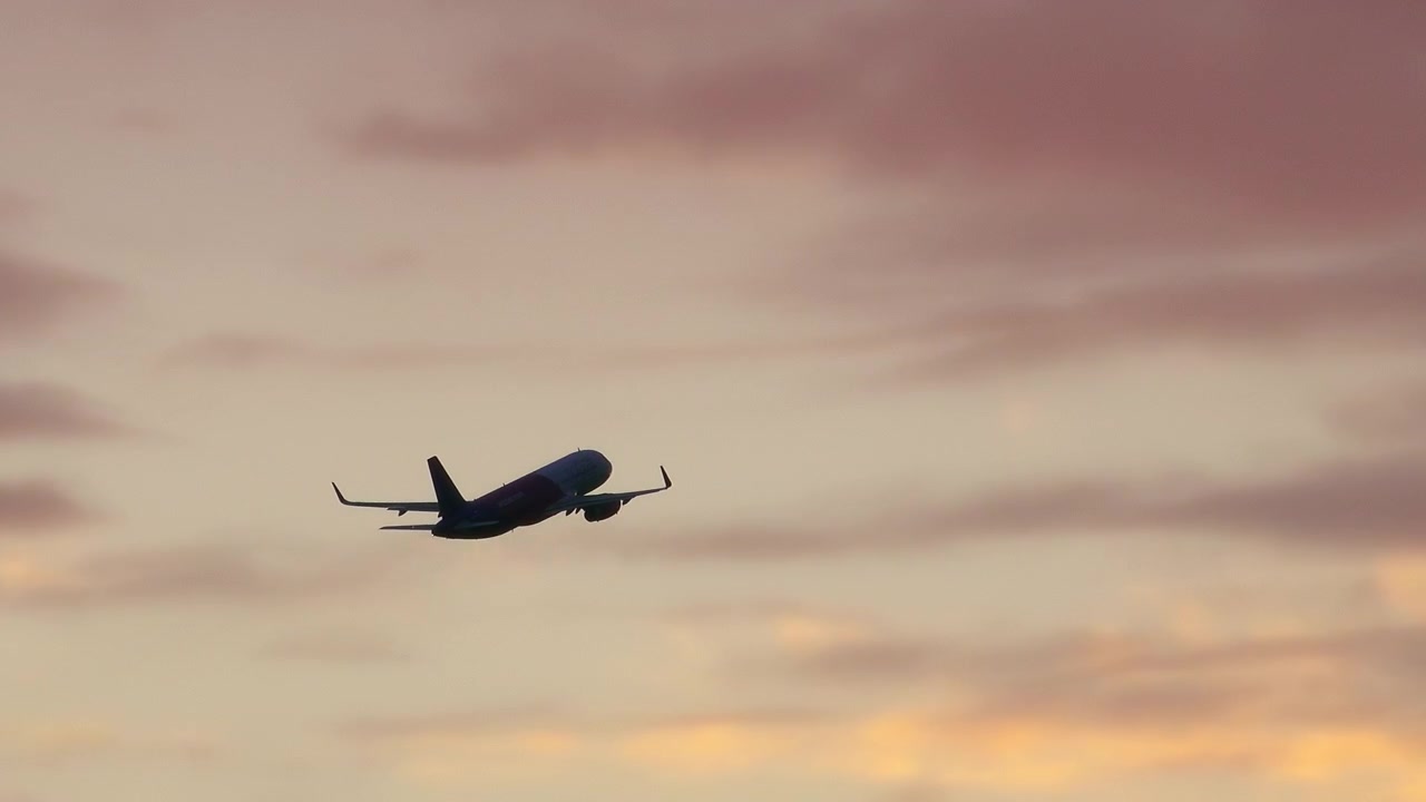 Avion de ligne en silhouette sur un ciel de coucher de soleil coloré