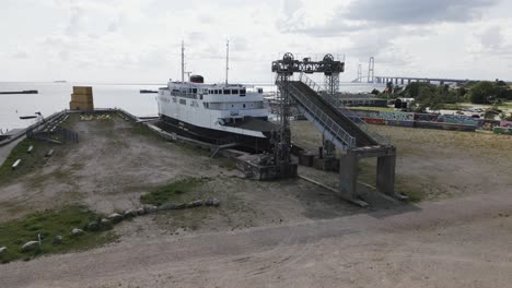 viejo barco en el puerto cerca de un gran puente sobre el mar