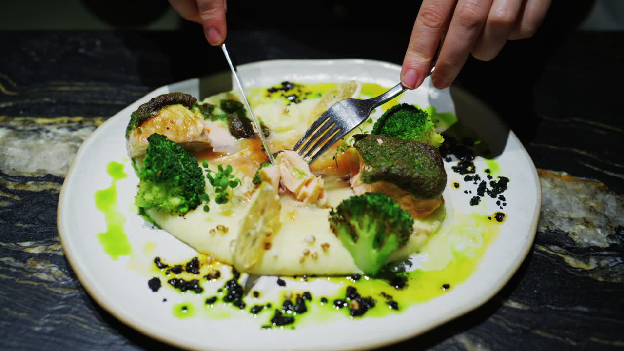 Fine dining plated fish dish with broccoli, creamy puree, herbs, and green sauce